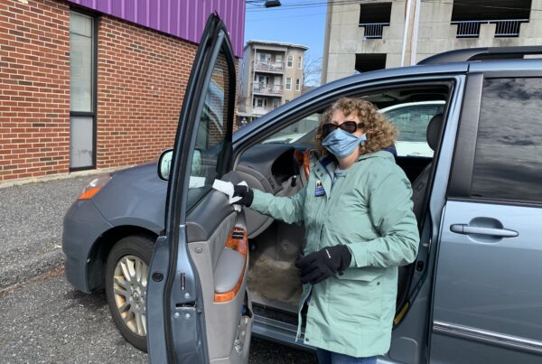 Volunteer driver wearing face mask sanitizing van